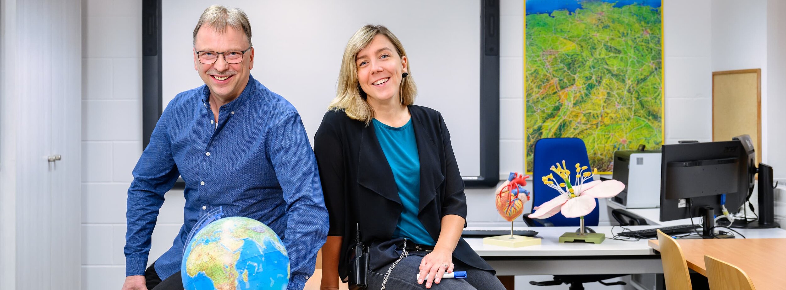 Ein Lehrer und eine Lehrerin im Klassenzimmer in einer Justizvollzugsanstalt