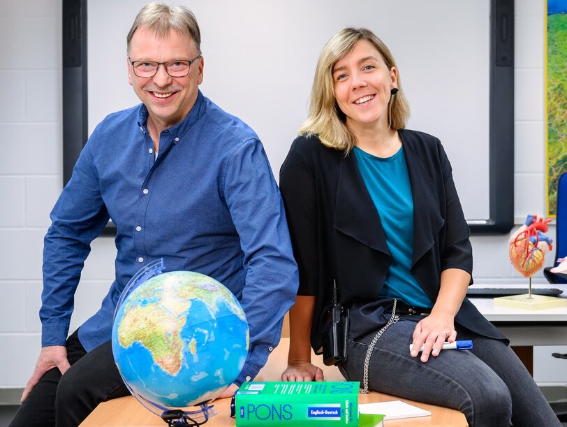 Ein Lehrer und eine Lehrerin im Klassenzimmer in einer Justizvollzugsanstalt