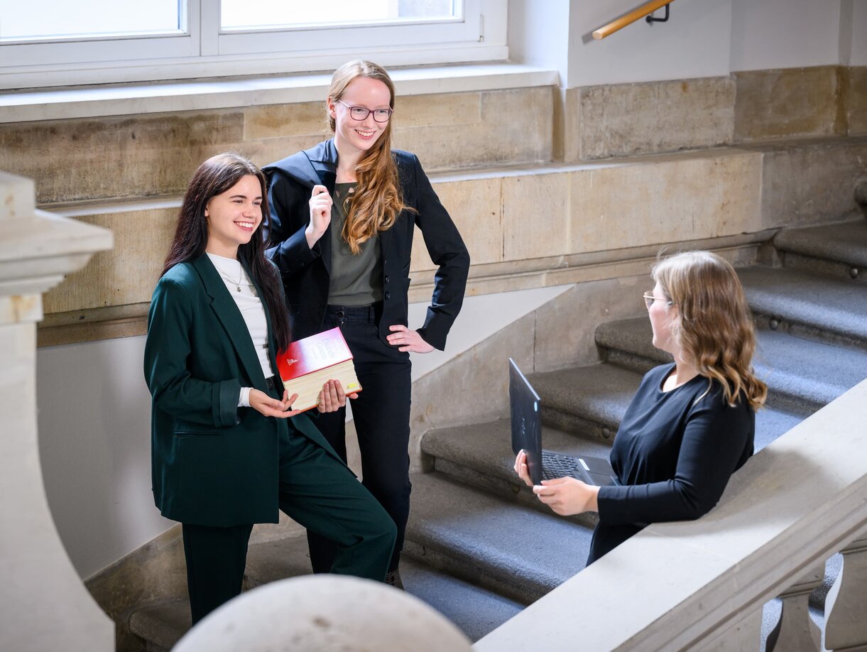 Drei Mitarbeiter der Rechtspfleger im Treppenhaus eines Gerichtsgebäudes