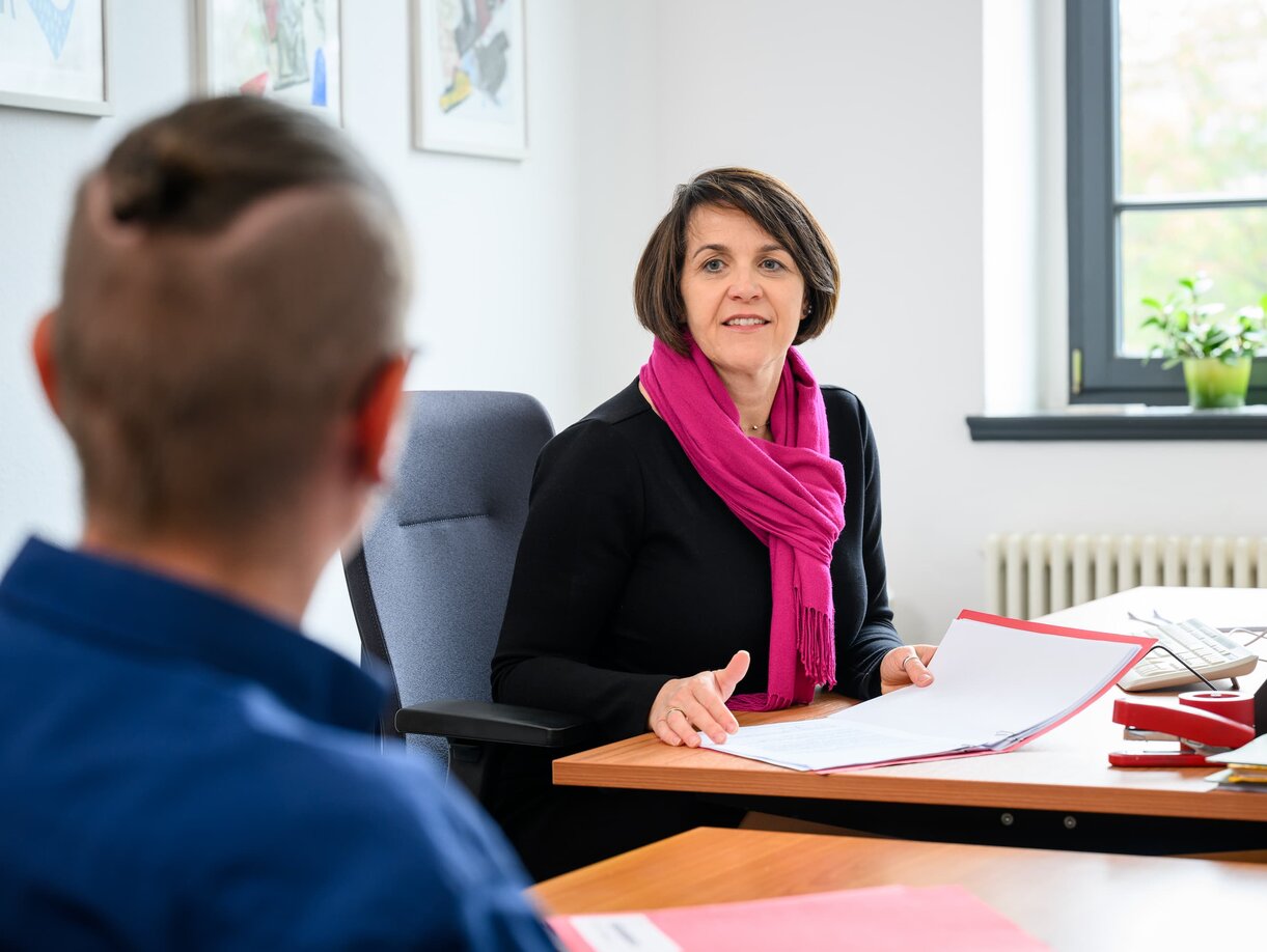 Ein Amtsanwalt und eine Amtsanwältin am Schreibtisch im Gespräch