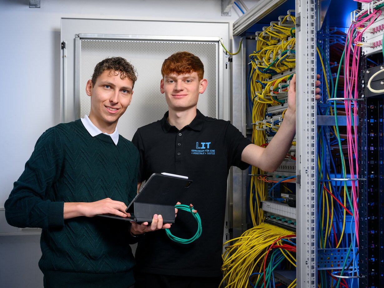 Zwei Mitarbeiter der Leitstelle für IT an einem Schaltschrank