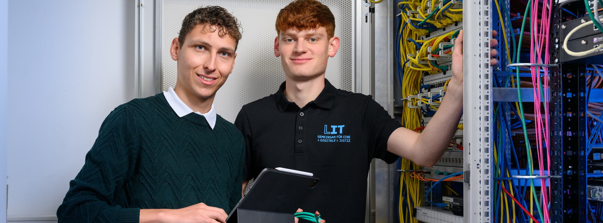Zwei Mitarbeiter der Leitstelle für IT an einem Schaltschrank