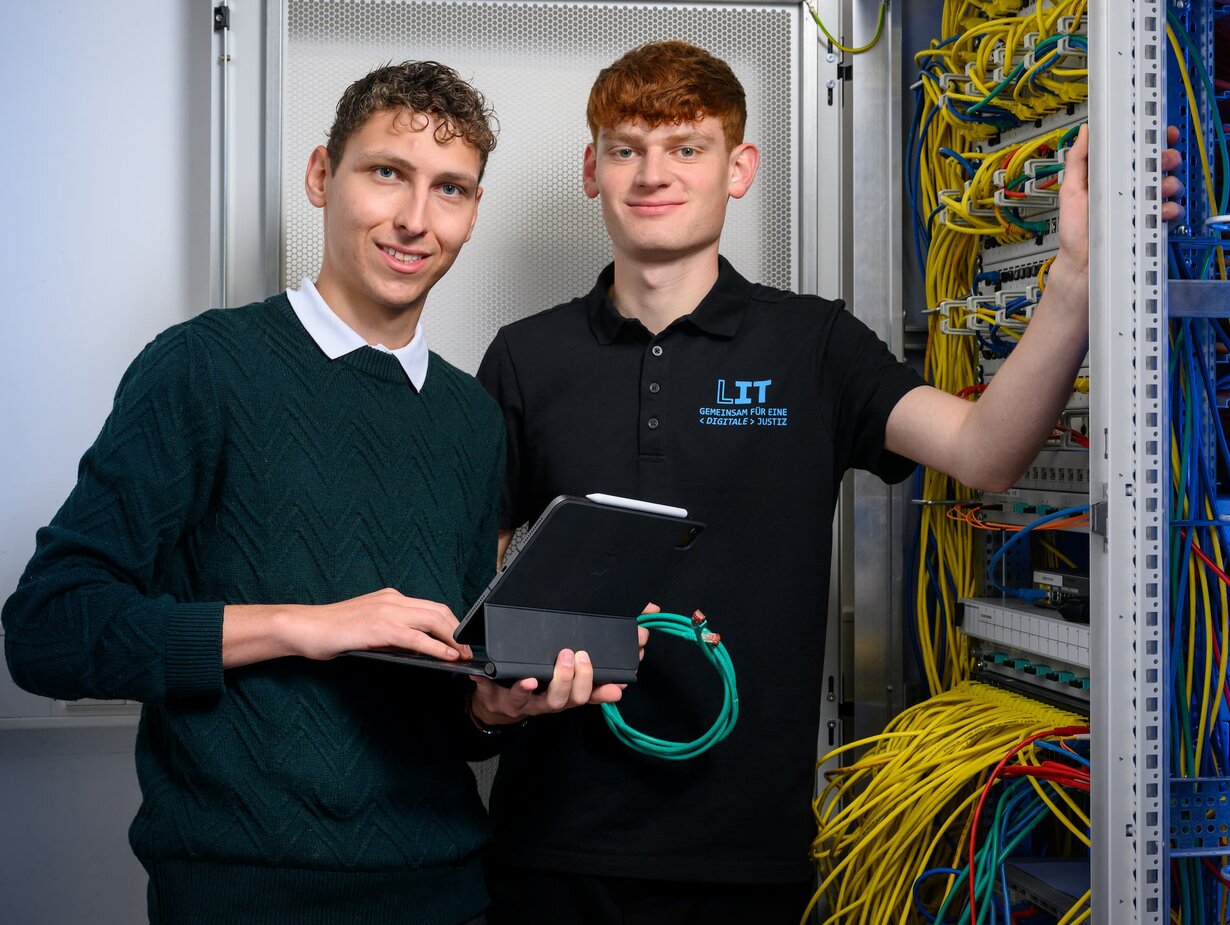 Zwei Mitarbeiter der Leitstelle für IT an einem Schaltschrank