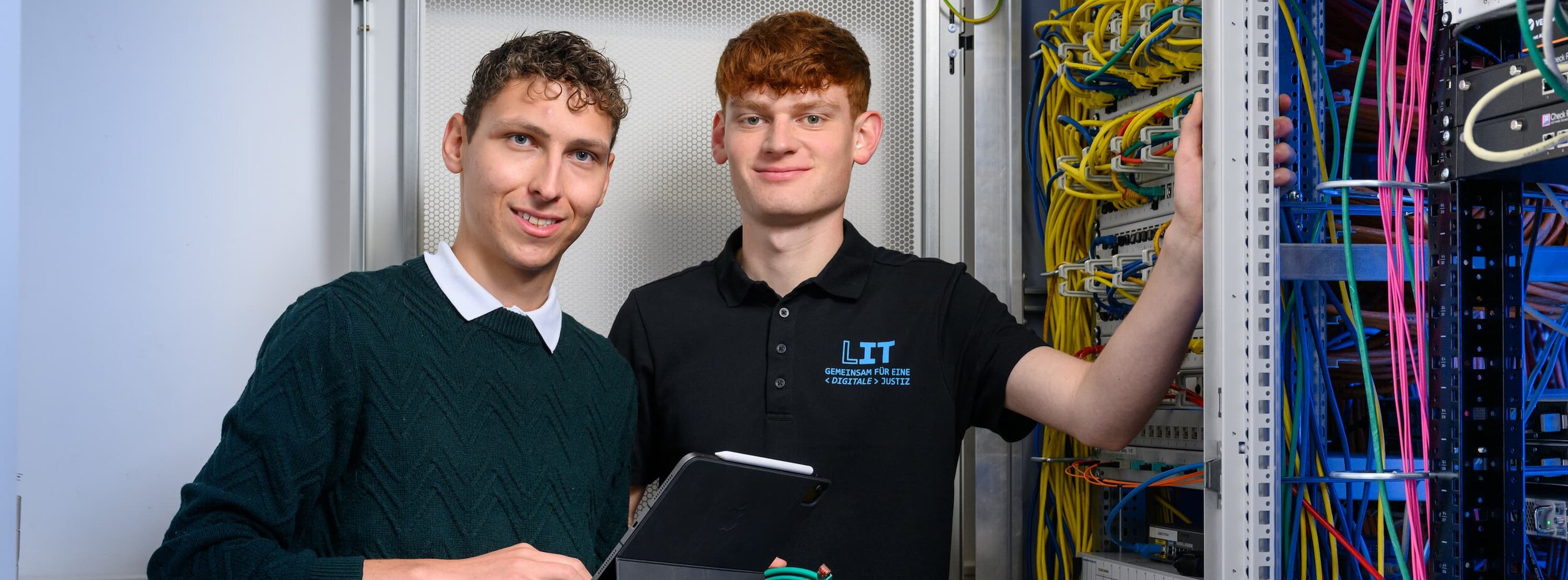 Zwei Mitarbeiter der Leitstelle für IT an einem Schaltschrank