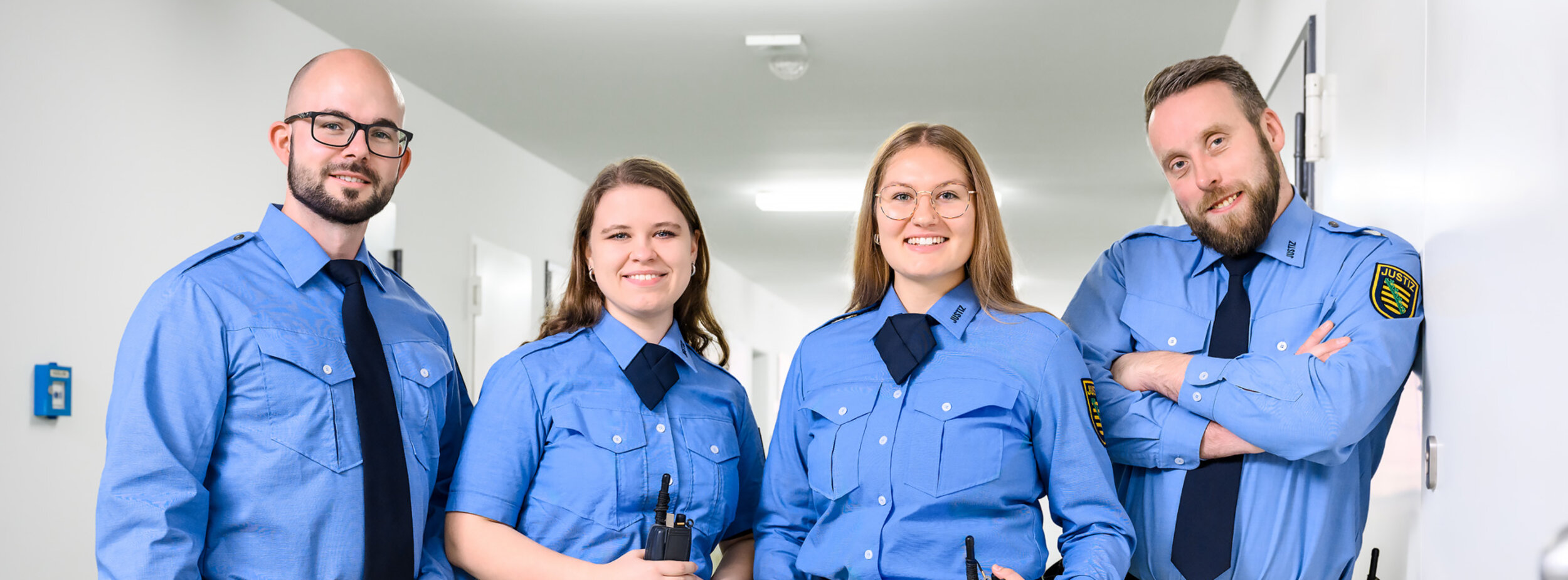 Vier Justizvollzugsbeamte stehen im Gang des Justizvollzugs