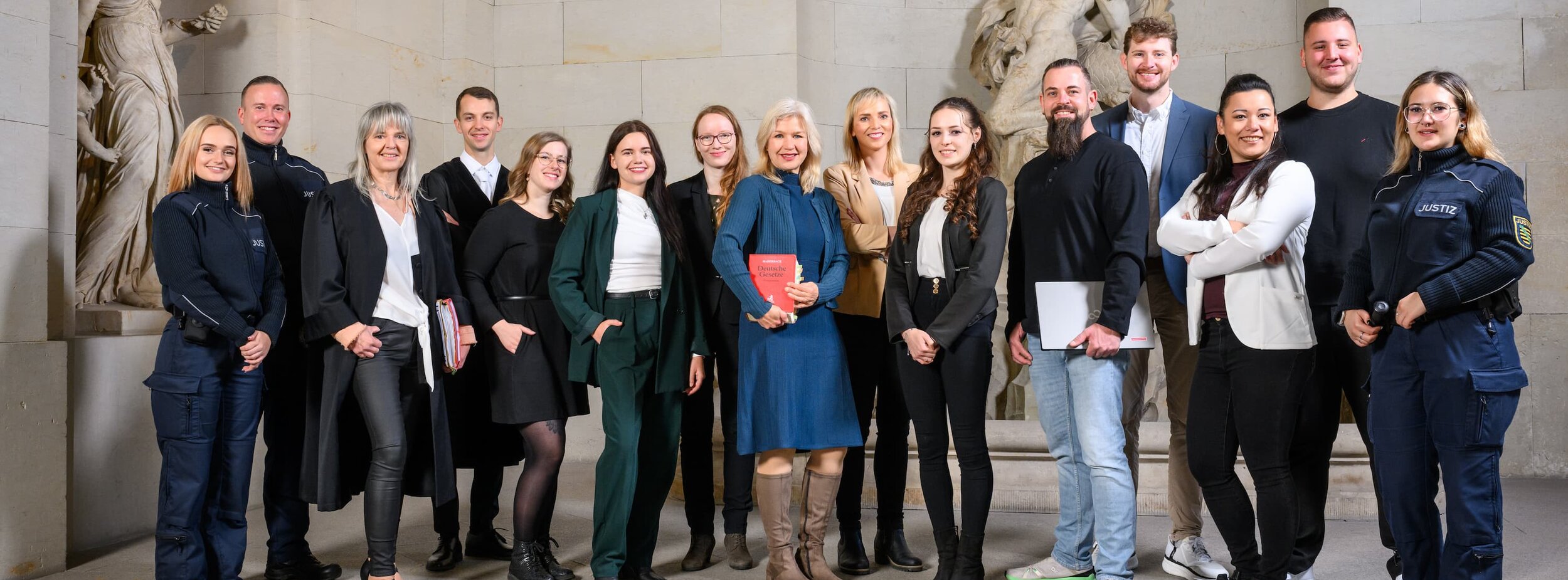 Eine Gruppe von Mitarbeitern verschiedender Fachgebiete beim Gericht steht im Treppenhaus