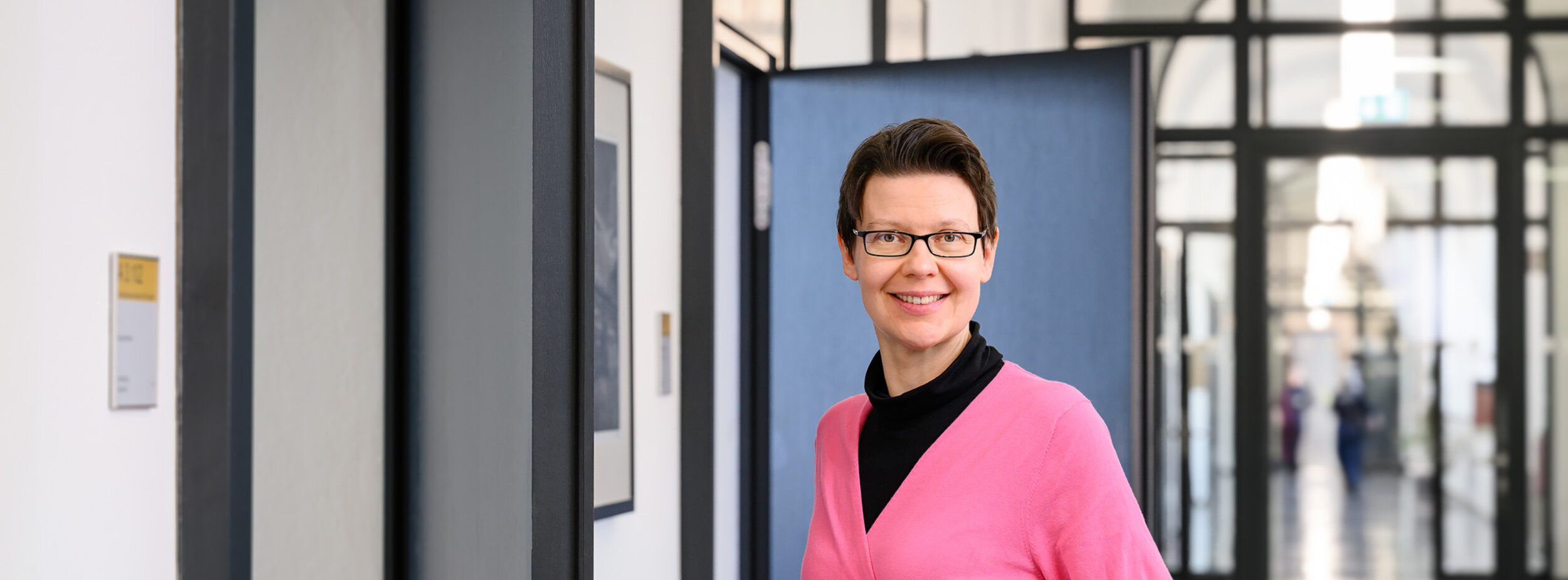 Eine Wirtschaftsreferentin auf dem Gang öffnet eine Tür im Gerichtsgebäude