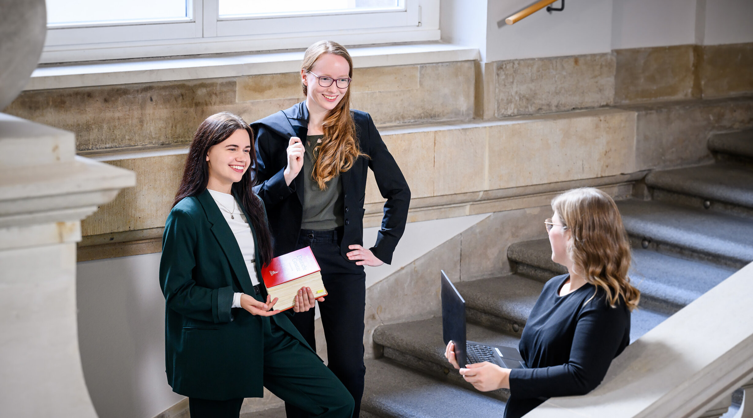 Drei Rechtspflegerinnen im Treppenhaus eines Gerichtsgebäudes
