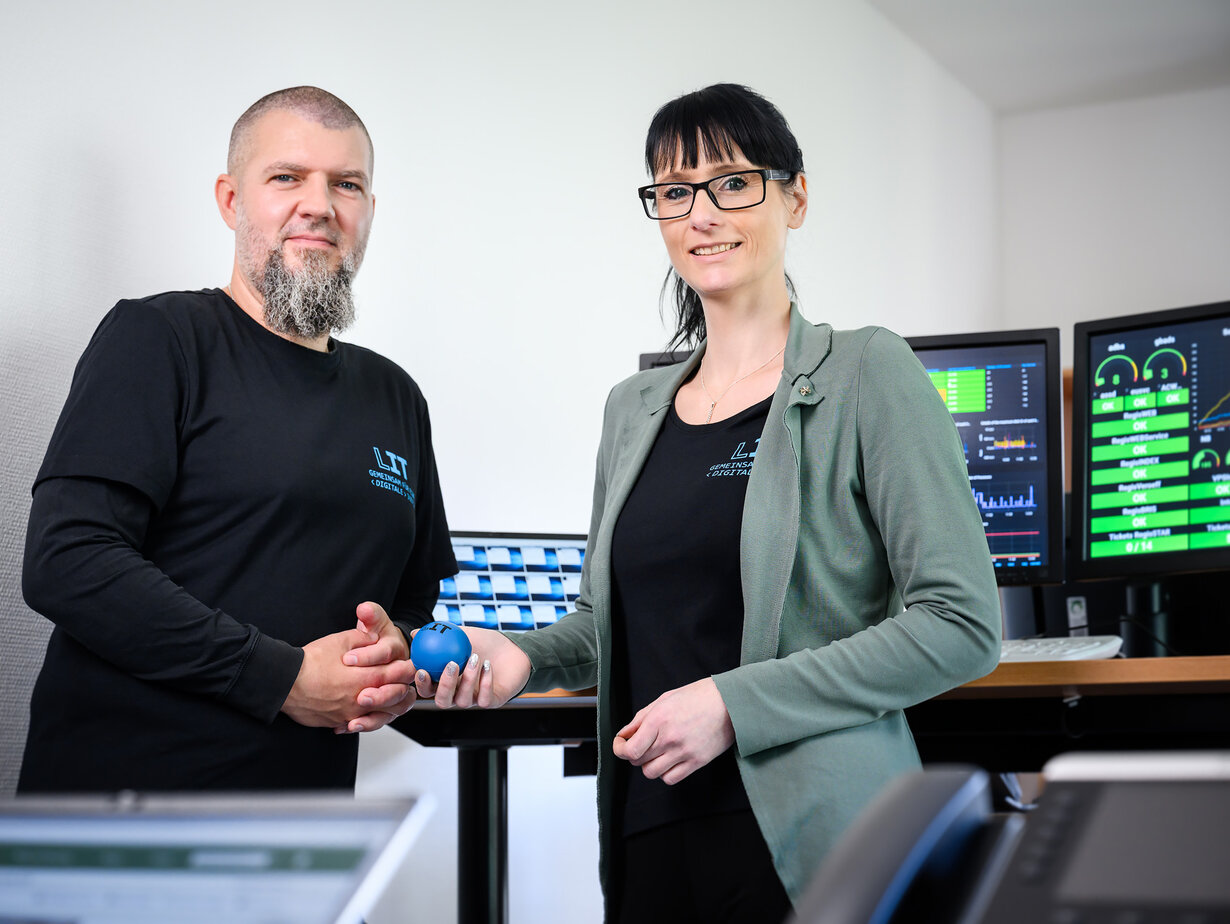 Ein Mitarbeiter und eine Mitarbeiterin der Leitstelle für IT beim Monitoren der Systeme