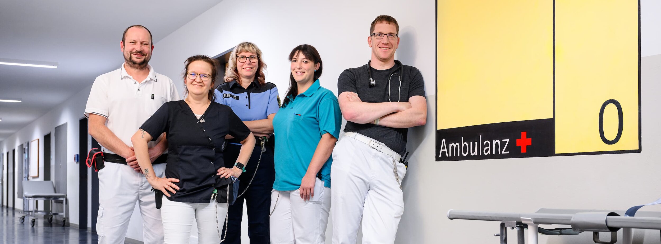 Fünf Mitarbeiter des medizinischen Dienstes stehen im Gang in einer Justizvollzugsanstalt