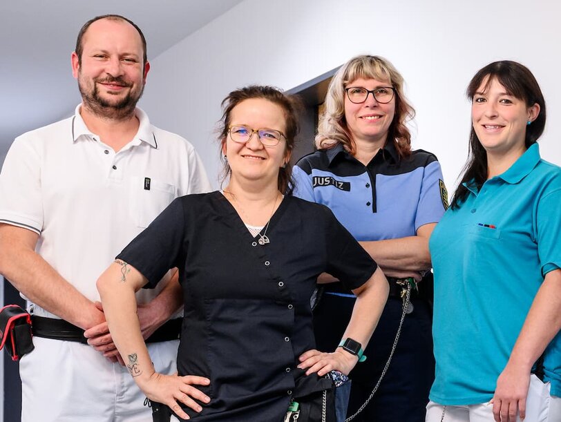 Fünf Mitarbeiter des medizinischen Dienstes stehen im Gang in einer Justizvollzugsanstalt