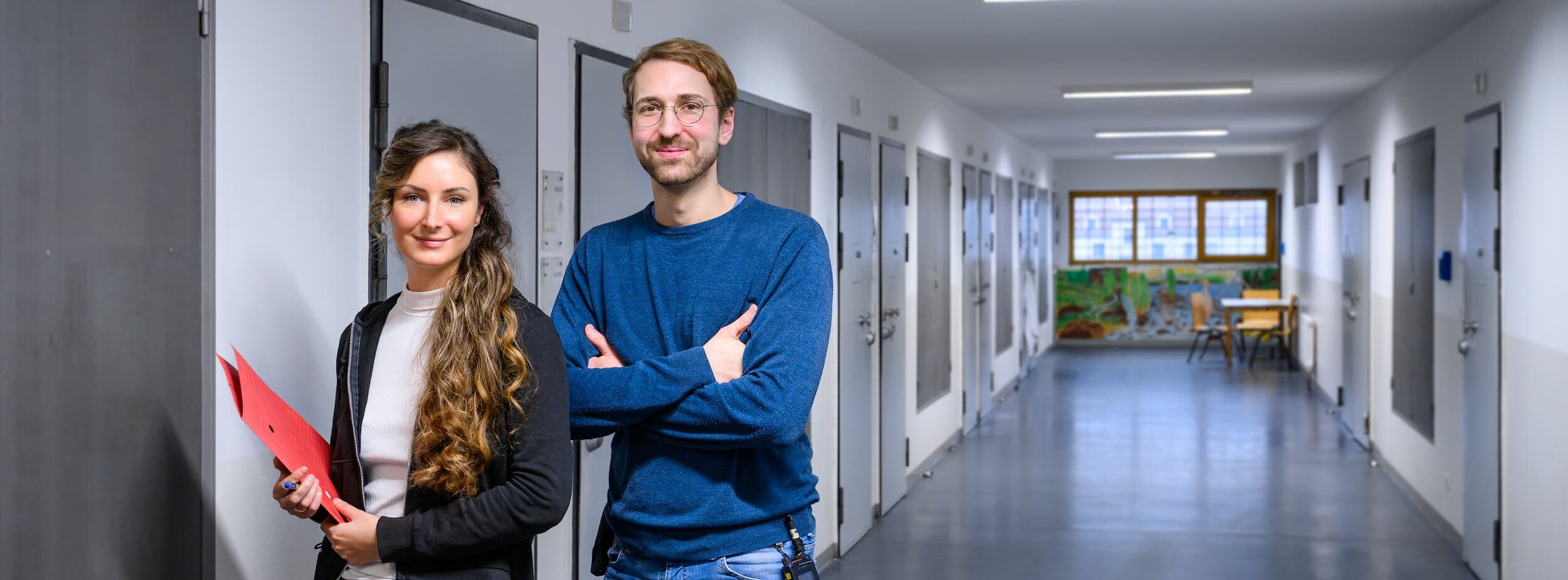 Eine Psychologin und ein Psychologe stehen im Zellen-Gang