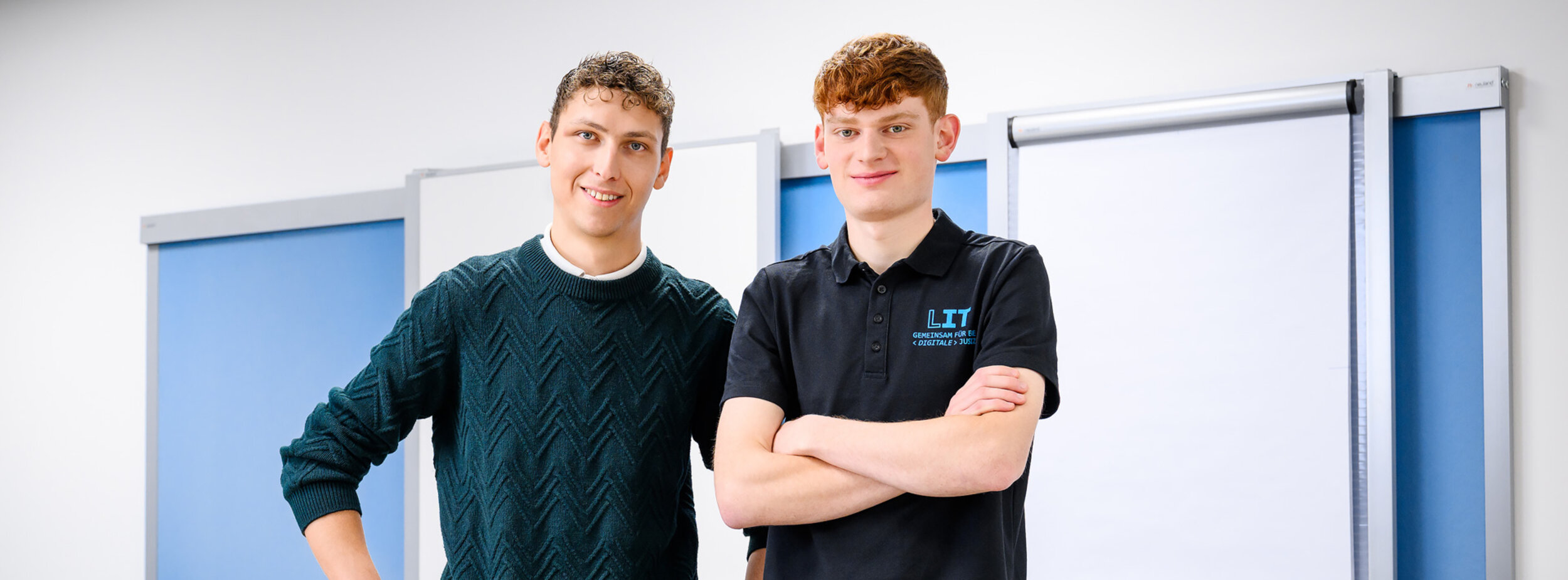 Zwei Mitarbeiter der Leitstelle für IT stehen in einem Schulungsraum