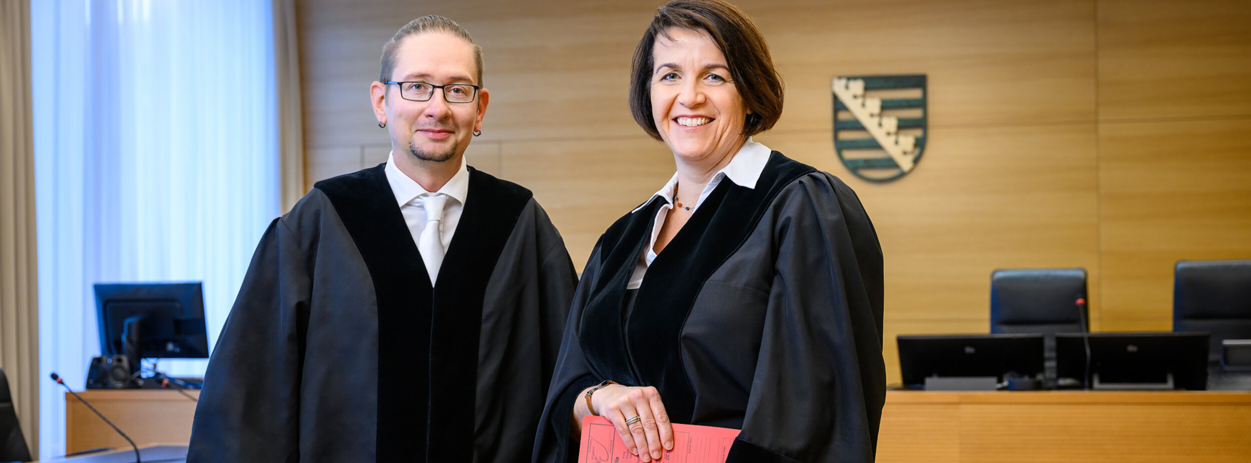 Ein Amtsanwalt und eine Amtsanwältin in einem Gerichtssaal
