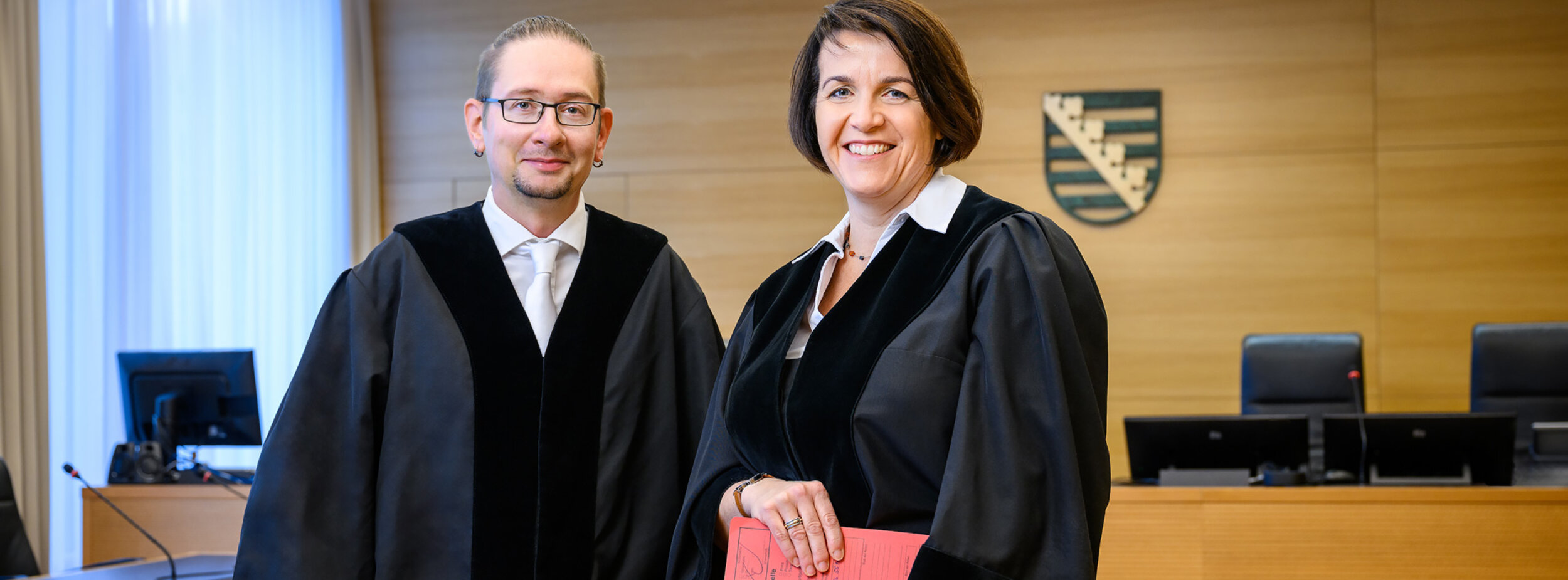 Ein Amtsanwalt und eine Amtsanwältin in einem Gerichtssaal