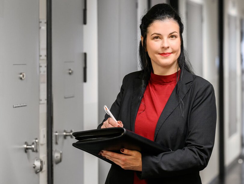 Eine Mitarebiterin für Soziale Arbeit steht im Zellen-Gang