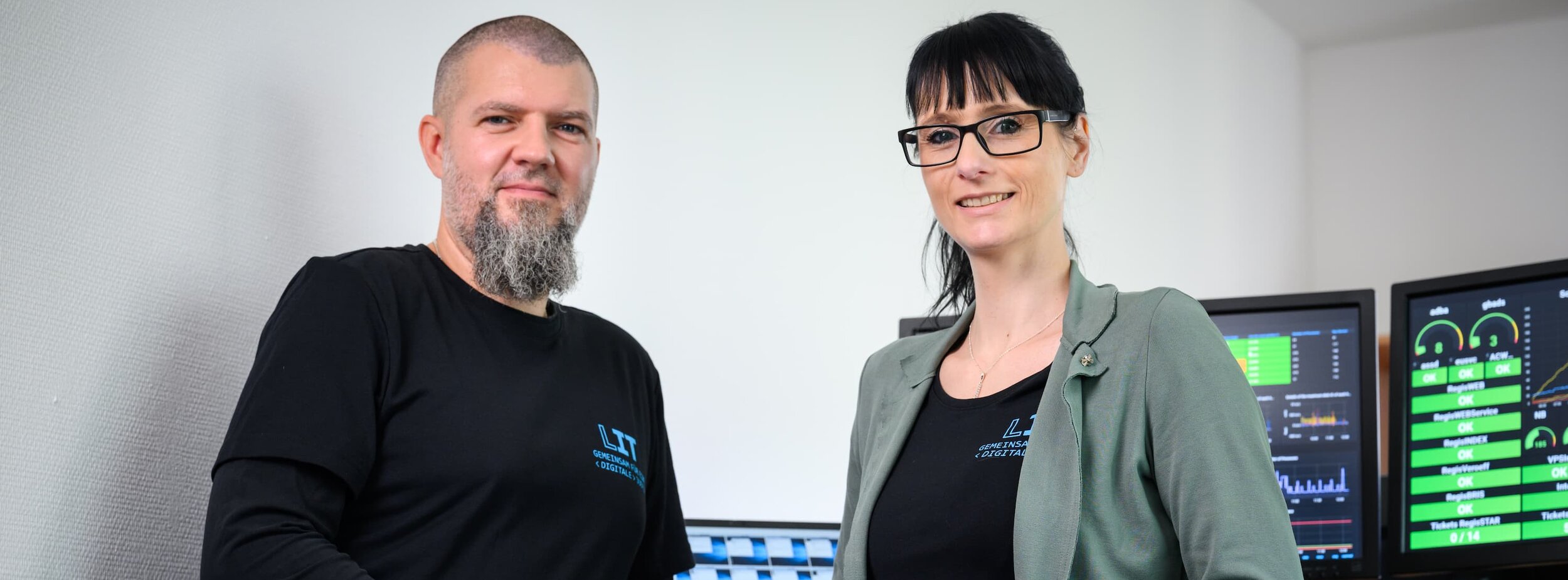 Ein Mitarbeiter und eine Mitarbeiterin der Leitstelle für IT beim Monitoren der Systeme