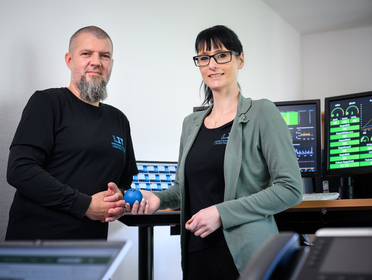 Ein Mitarbeiter und eine Mitarbeiterin der Leitstelle für IT beim Monitoren der Systeme