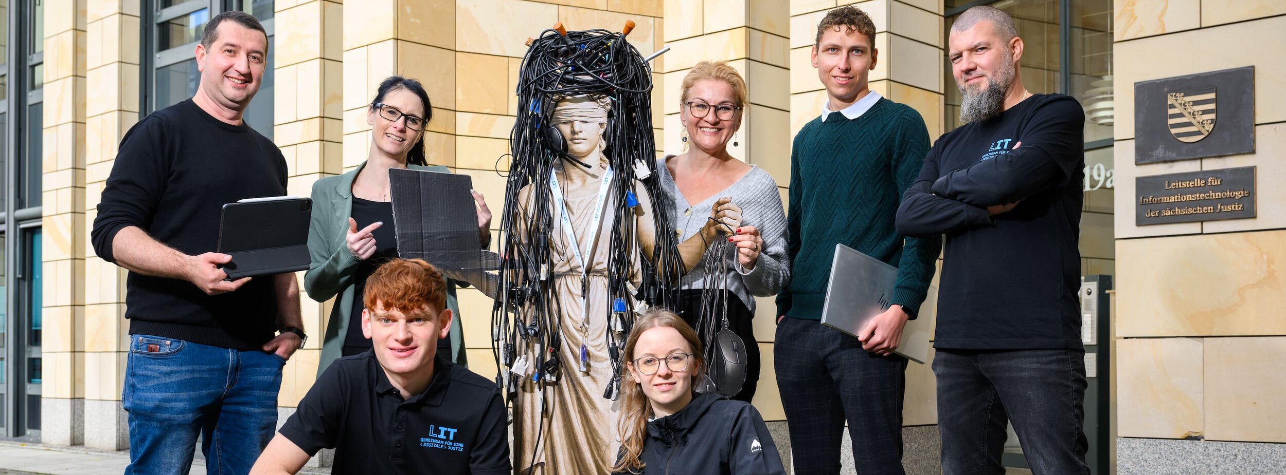 Bild-Collage mit einer Gruppe von Mitarbeitern verschiedener Fachgebiete der Leitstelle für IT vor einem Gebäude und in der Mitte eine Statue vollgehangen mit Kabeln