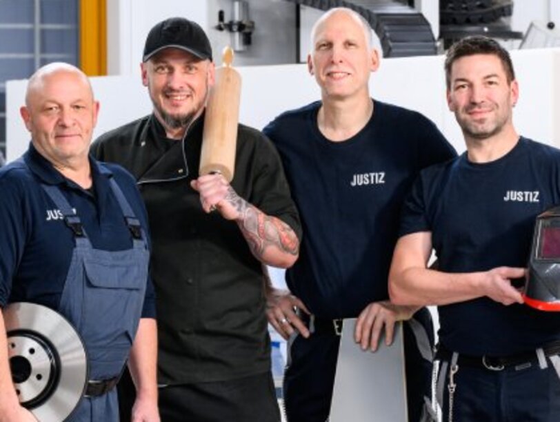 Mitarbeiter eines Arbeitsbetriebes im Justizvollzuges stehen in einem Werkraum