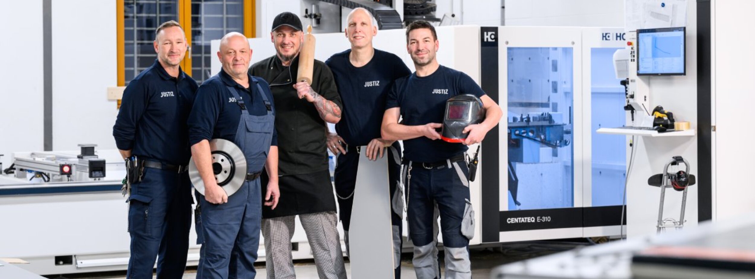 Mitarbeiter eines Arbeitsbetriebes im Justizvollzuges stehen in einem Werkraum